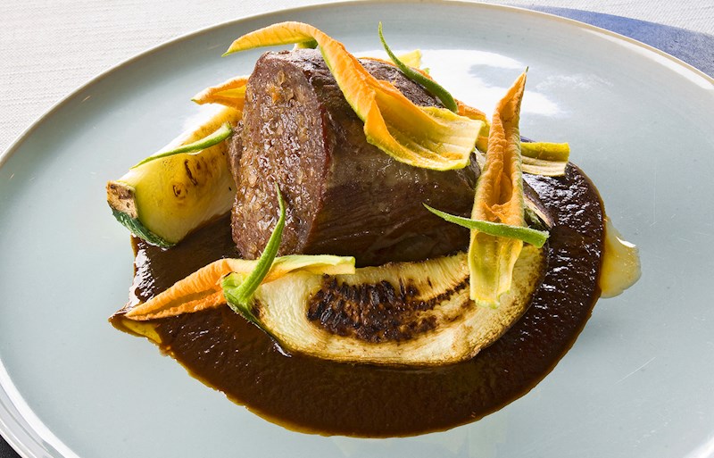 A plate of mole negro with chicken and rice, artfully presented