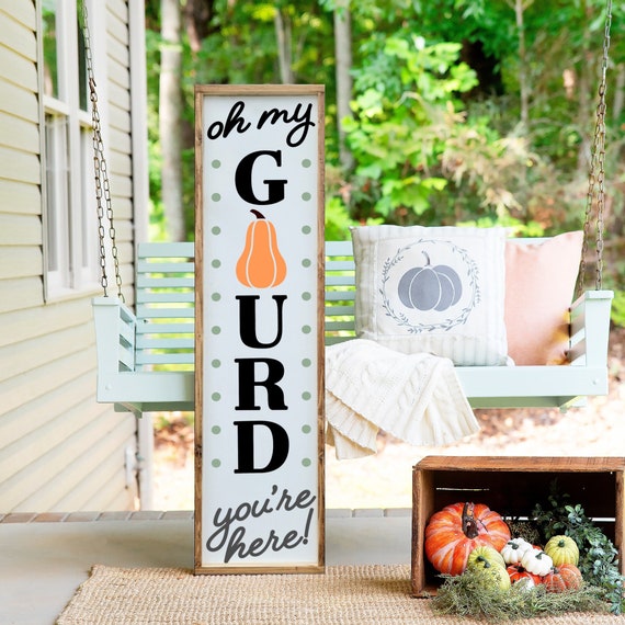 A rustic wood sign with a farmhouse-themed quote painted on it.