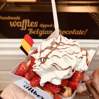 A stack of freshly made Belgian fries in a paper cone, served with a generous dollop of mayonnaise at the Frietmuseum in Bruges
