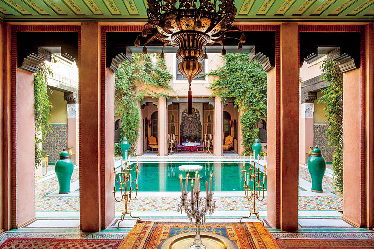 Panoramic view of the courtyard with the emerald-green pool and surrounding architecture (golden hour, warm tones).