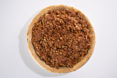 Image of sliced apples being tossed with spices in a bowl, showing the preparation stage of mixing the apple filling ingredients.