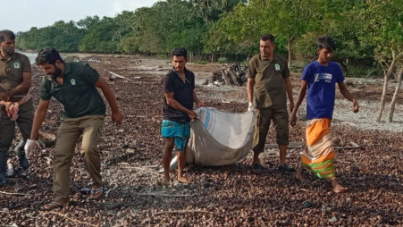 Volunteers sorting through collected plastic debris on Kamilo Beach, separating it into different types for recycling or disposal.