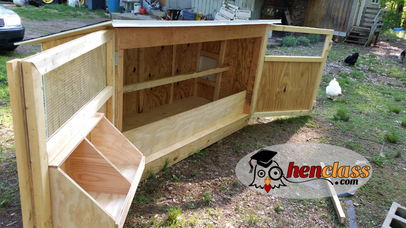 A chicken coop with a completed roof, showing the use of reclaimed roofing materials