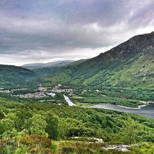 Neist Point lighthouse at sunset with dramatic cliffs and ocean waves