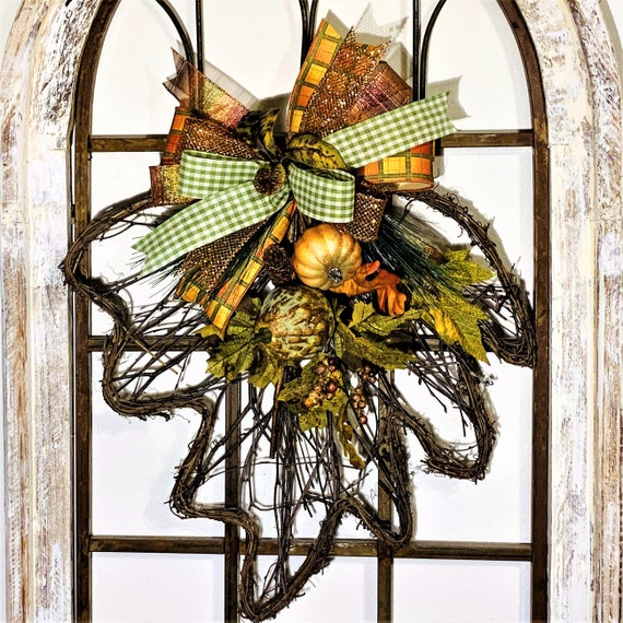 A rustic fall entryway decorated with a vintage scale, pumpkins, and other natural elements