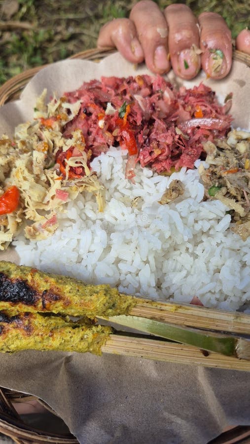 A traditional Balinese meal served with love in a round woven bamboo plate.