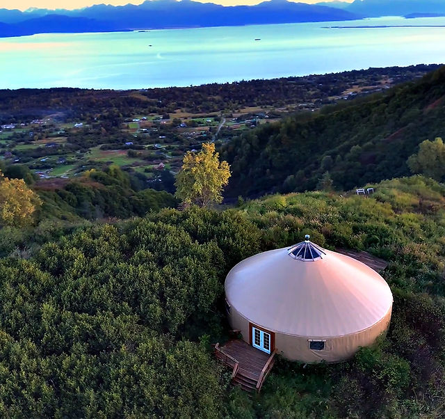 Yurt Door Struggle: Close-up, slightly humorous shot of Agnes, Beatrice, and Carol struggling with the yurt door's locking mechanism. Focus on the expressions of confusion and amusement. Use natural light, with a slightly warm color temperature.