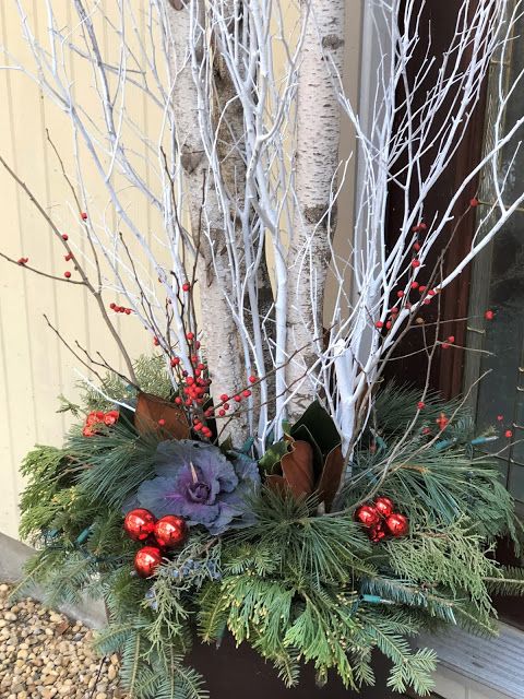 Close-up of felted wool balls in white, gray, and deep red, adding a subtle pop of color to the neutral palette of a Scandinavian mantel.