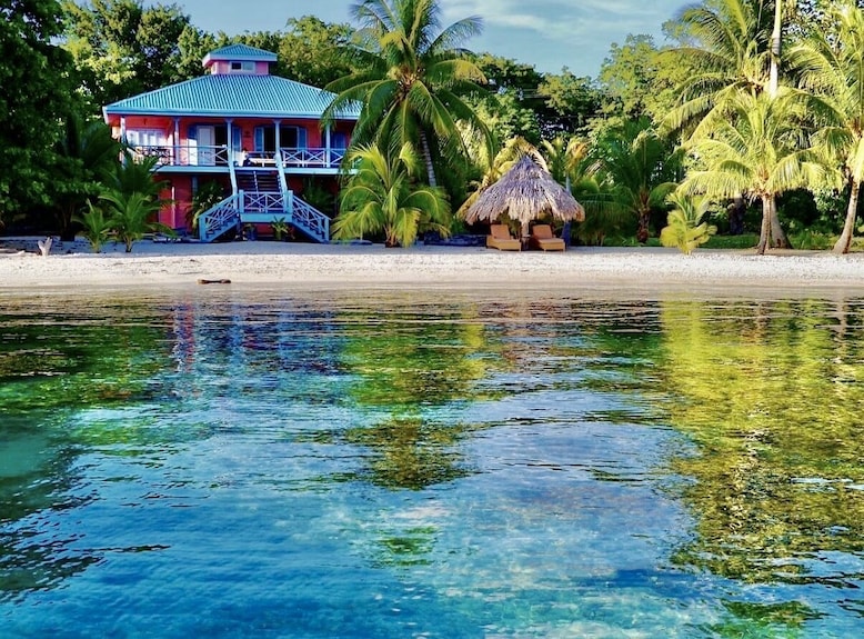 A SUP yoga class in action at sunset, with clear, vibrant colors and sharp detail. This image captures the peacefulness and beauty of practicing yoga on the water in Utila.