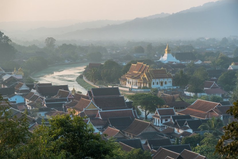 Luang Prabang street scene with French colonial architecture and monks walking by