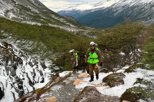 Alex standing at the base of the Torres del Paine, smiling and covered in mud, with the iconic towers in the background.
