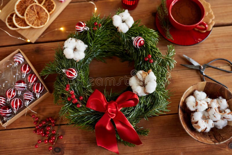 A finished natural holiday wreath, showcasing the completed project with evergreen branches, dried orange slices, cinnamon sticks, and burlap ribbon.