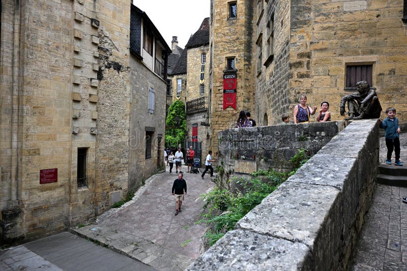 Peasants visibly working within the town, some tilling fields, others crafting tools, and others transporting resources, showcasing the activity and dynamic nature of managing a thriving medieval settlement in Manor Lords.