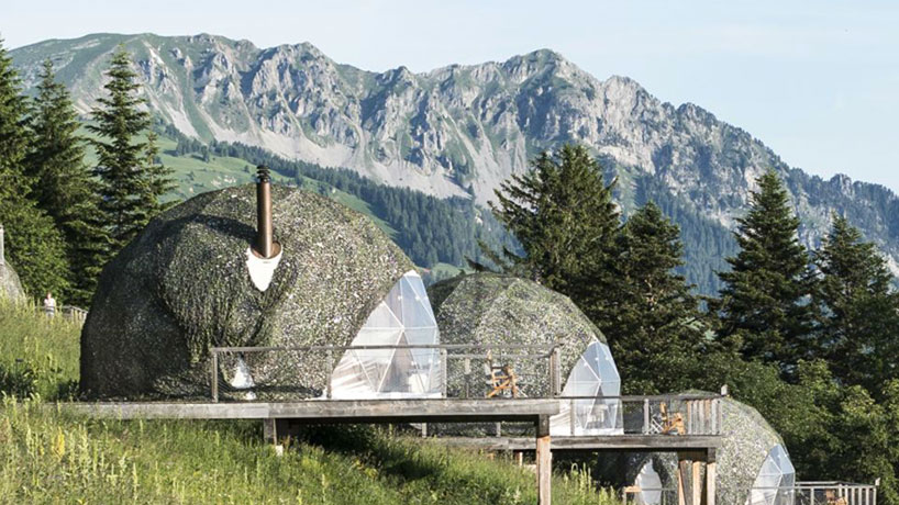 Hikers on a trail overlooking a lush green valley in Graubünden