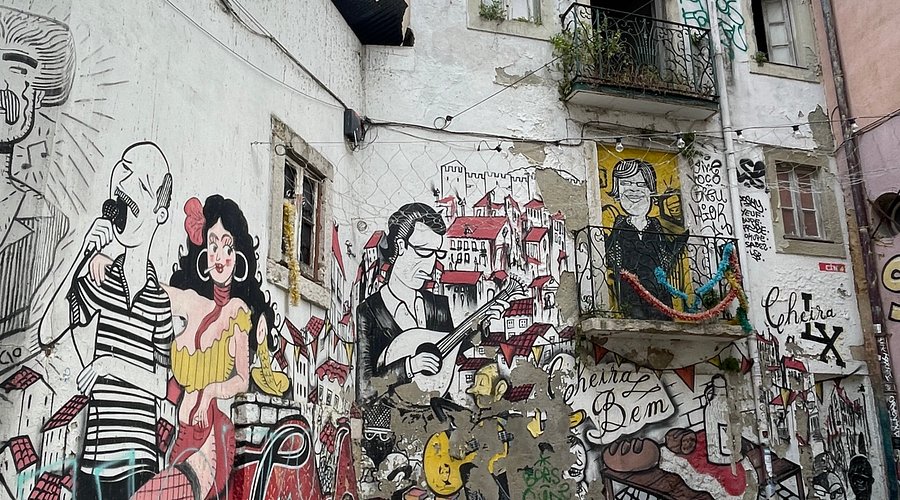 Panoramic view of Coimbra from Selina Hostel's terrace showcasing terracotta rooftops and the University clock tower