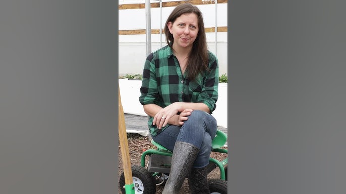 Close-up, eye-level shot of a person using a broadfork in a garden bed, showing the tool penetrating the soil and creating aeration, rich dark earth, healthy plant roots visible if possible, natural light, earthy tones, focus on the tool's mechanics and soil texture.