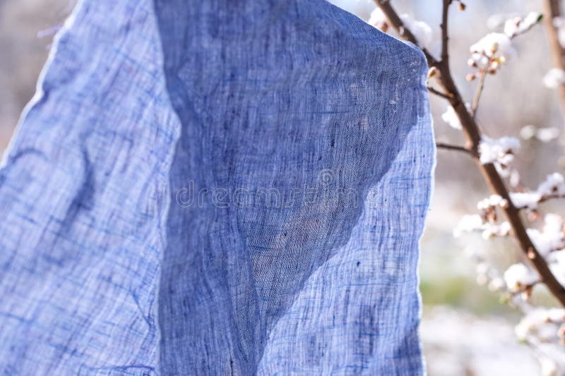 Naturally dyed linen napkins and cotton tea towels hanging on a clothesline to dry.