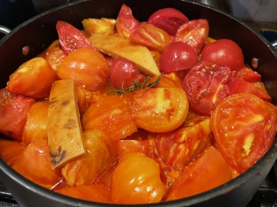 Close up of tomatoes being prepped to be cooked down into tomato sauce