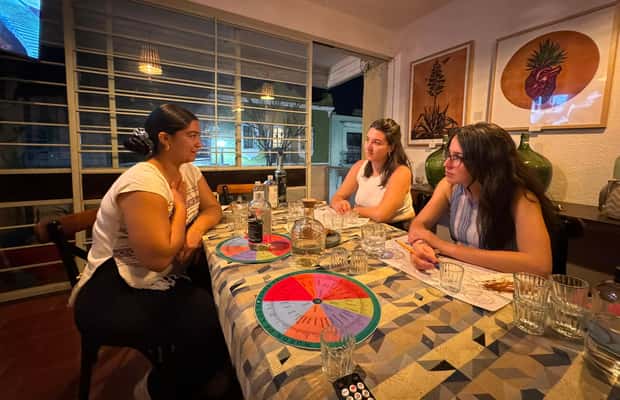 Mezcal photo: A Mezcal tasting flight in a dimly lit restaurant, showing the different colors and textures of the Mezcal in small copitas (glasses). The background should be blurred, highlighting the warm, inviting atmosphere of Los Danzantes.