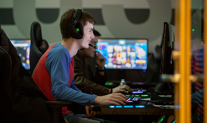 A close-up of a computer screen displaying the Counter-Strike 2 loading screen, with a blurred image of a player in the background, symbolizing the immersive and competitive environment of the game. The alt text suggests this image represents the stakes of maintaining a fair and enjoyable gameplay experience.