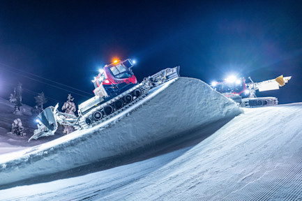 A wide shot of a fat biker silhouetted against the snow-covered fells of Levi