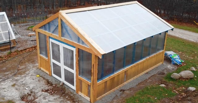 Another angle of a DIY greenhouse featuring repurposed materials
