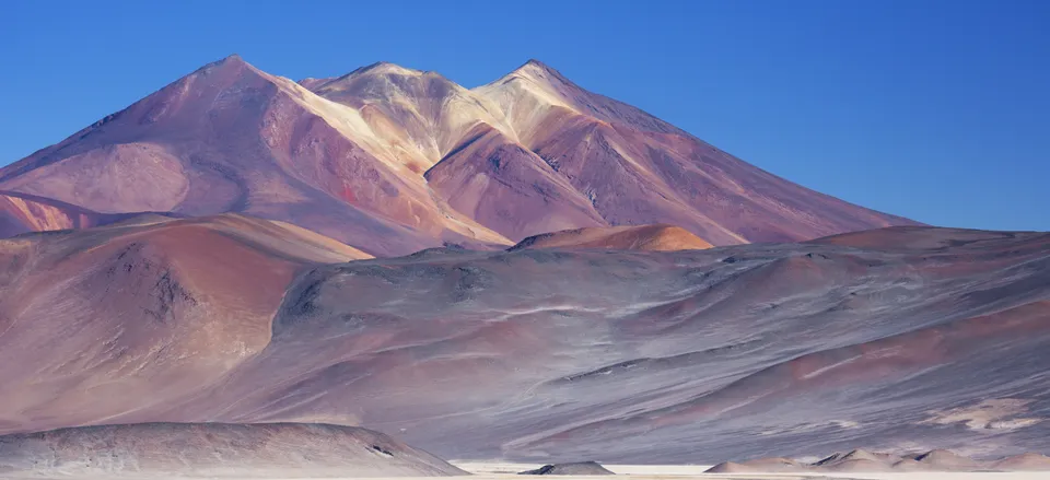 A stunning night sky photo over the Elqui Valley, showing the Milky Way in all its glory, with a couple sitting under the stars, perhaps with a telescope nearby.