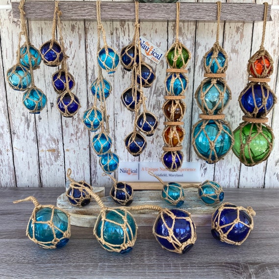 A close-up of colorful sea glass pieces on a beach, with golden hour lighting.