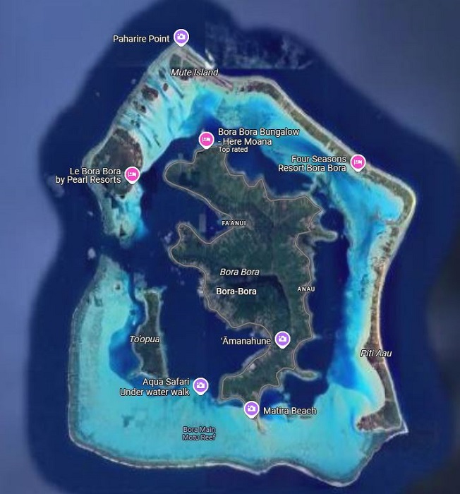 An aerial view of the overwater bungalows at the Four Seasons Resort Bora Bora, showcasing the pristine turquoise lagoon and lush tropical landscape.