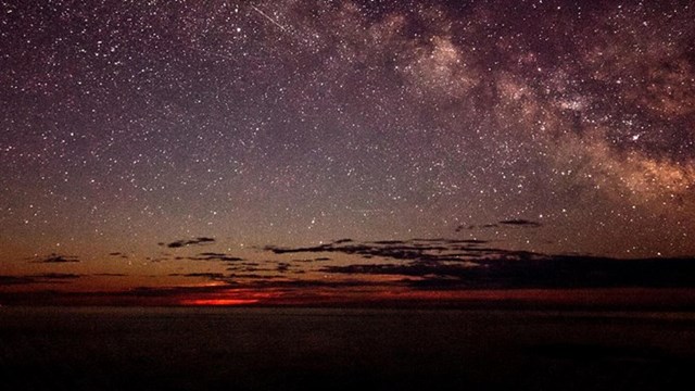 Otter Cliffs along Park Loop Road in Acadia National Park, showing the dramatic cliffs plunging into the ocean with colorful fall foliage above.