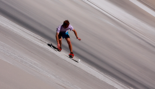 Sandboarder silhouetted against the Atacama sunset