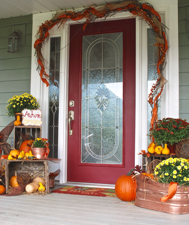 Farmhouse fall porch with pumpkins, mums, and a cozy blanket
