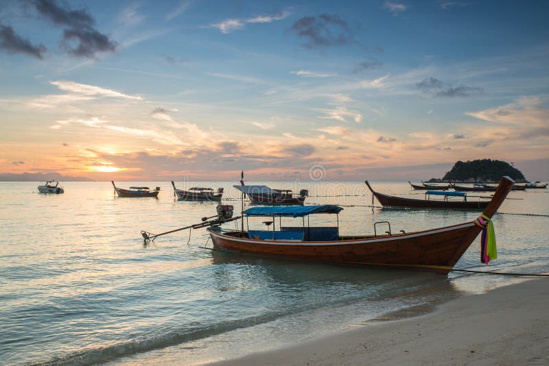 A panoramic sunrise view from a mountain overlooking a beach and the ocean. The image showcases the breathtaking landscape and the vibrant colors of the sunrise at Mount Maunganui, New Zealand.