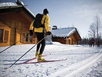 Hands carefully cutting a snow block with a knife