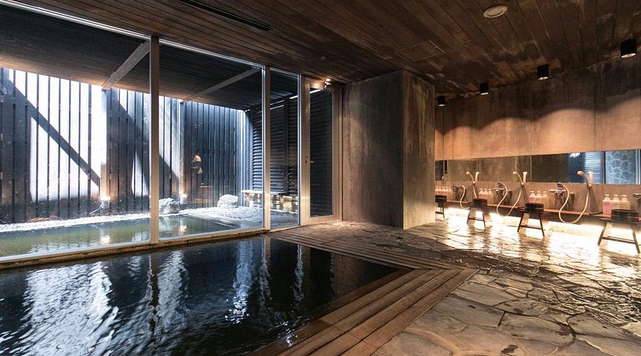A photographer on a snowmobile, capturing a majestic shot of a snow-capped mountain range under a clear blue sky. Include a close-up of the photographer's camera settings for winter photography.