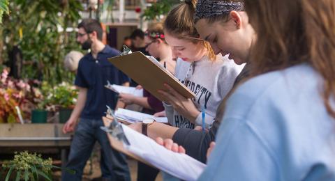 A customer proudly displaying their GreenThumb Goodies plant on a plant shelf, participating in the #GreenThumbGoodiesShelfie challenge.