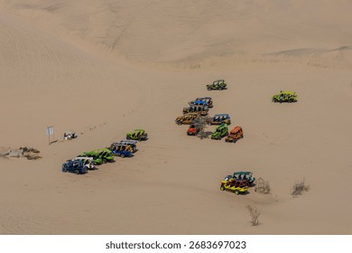 A wide-angle shot of a sandboarder mid-air against a backdrop of endless dunes, capturing the speed and scale