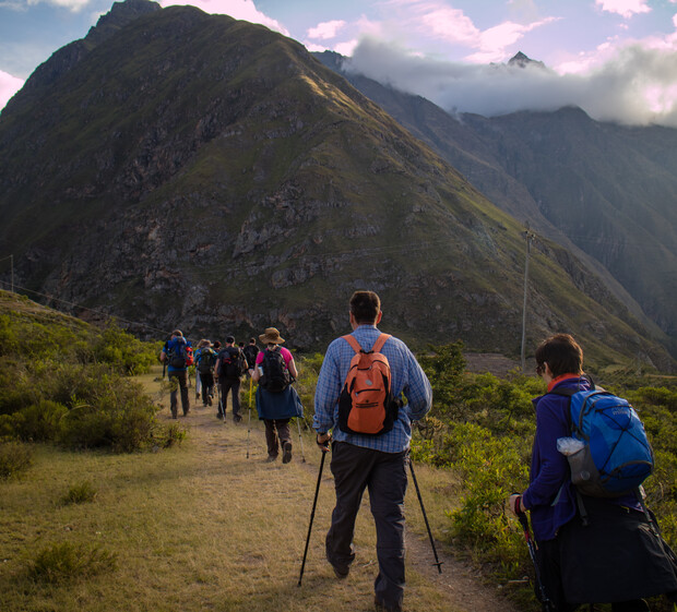 A solo female traveler hikes the Inca Trail, breathing deeply, with Machu Picchu in the distance, showcasing the physical effort and the rewarding experience of connecting with nature and ancient history.