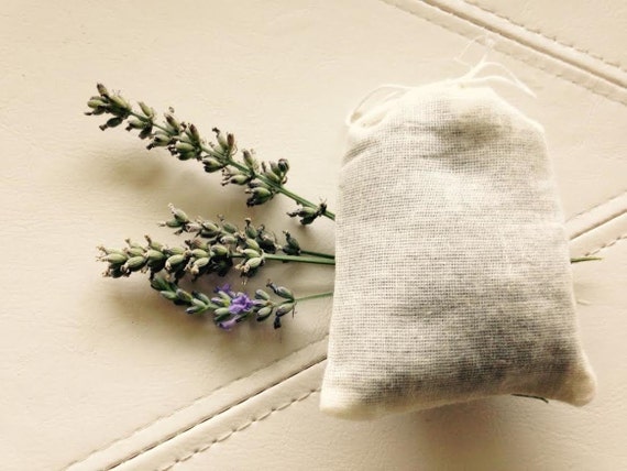 Step-by-step photo series: Hands carefully sewing a muslin sachet filled with dried herbs. Focus on the needle and thread. Soft, warm light. Clean, minimalist background. Photorealistic.