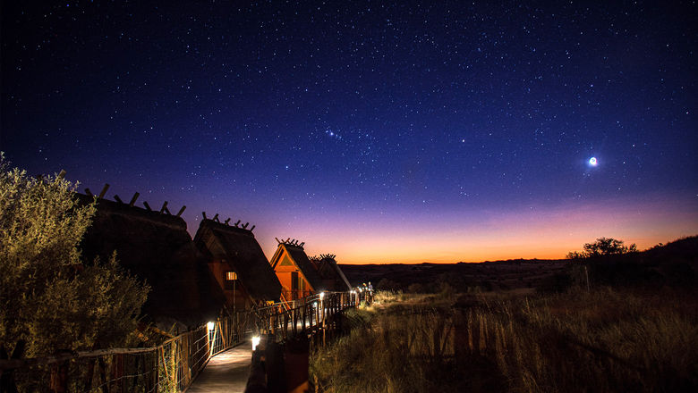 An astrophotography setup in the Namib Desert, featuring a camera, lens, star tracker, and tripod.