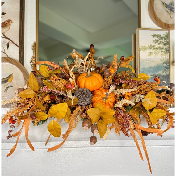 A close-up shot of bittersweet vine gracefully cascading down the side of a farmhouse mantel, showcasing its vibrant orange berries and natural, flowing form.