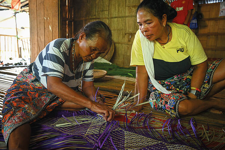 Kayaks in Lake Kenyir at dusk, heading towards a hidden waterfall, surrounded by rainforest