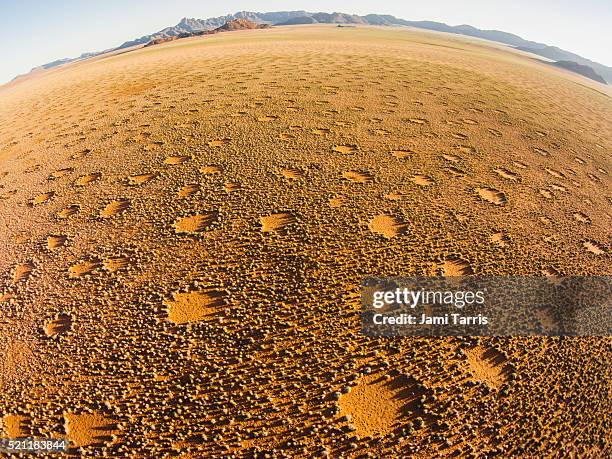A hiker silhouetted against Zabriskie Point's formations at sunset. Alt text: A hiker at sunset in Death Valley's Zabriskie Point, highlighting the beauty and challenge of desert hiking.