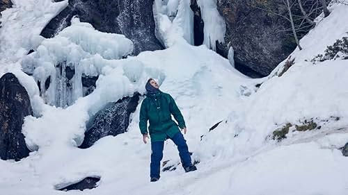 A person Nordic walking with llamas with Aneto peak in the background in Benasque Valley, Spain