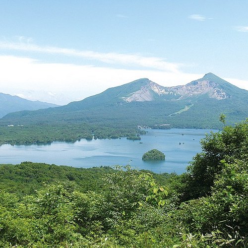 A diver emerging from a hole in the ice, surrounded by massive drift ice formations in the Sea of Okhotsk.