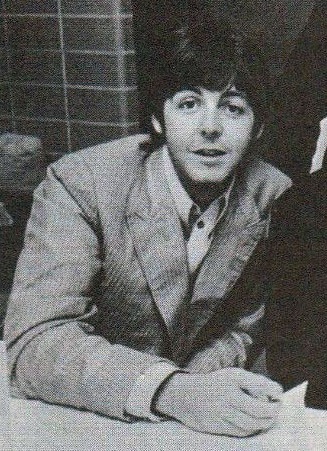 A black and white image of Jimmy Page with a guitar.