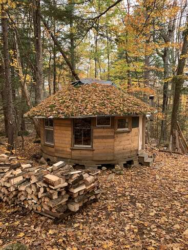 Gathering fall leaves for composting. A person raking leaves into a pile, showing the abundance of leaves available.