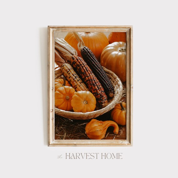 Close-up of a rustic wooden bowl filled with gourds, mini pumpkins, pinecones, acorns, and colorful leaves, showcasing a natural autumn centerpiece.