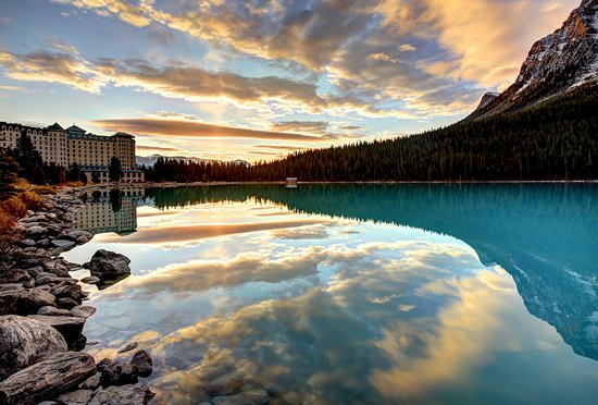 A long exposure shot of a yurt with warm interior lighting against the backdrop of the Altai Mountains under a starry sky, highlighting the blend of luxury and wilderness