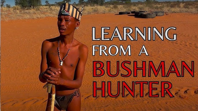 A Bushman tracker, face weathered and wise, pointing towards a nearly invisible animal track in the ochre sand under the harsh midday sun. The shot highlights the stark contrast between the tracker's knowledge and the seemingly empty landscape.